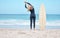 Surfing, stretching and woman surfer on beach standing by surfboard. Blue sky, ocean and girl ready to surf, doing