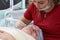 A surgeon beautician shows on a woman of advanced age the methods of rejuvenation and lifting of the skin