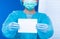 Surgeon doctor hold empty blank paper document. Medical person wear blue uniform glove mask in hospital to show responsibility