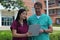 Surgeon or Doctor or Physician or Clinician and Asian Nurse Stand in Front of Hospital Discussing Patient Chart