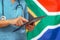 Surgeon or doctor using a digital tablet on the background of the South Africa flag