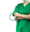 Surgeon doctor wear green scrubs shirt uniform and green face mask. Physician hand holding stethoscope. Healthcare professional.