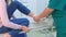 Surgeon examines patient woman leg after surgery unwinding bandage in hospital.