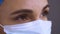Surgeon`s face in a medical protective mask, side view, close up. Healthcare professional wearing a surgical cap, mask