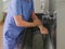 A surgeon washes his hands under a faucet in a stainless steel wash-hand basin. Preparing for a surgical operation