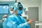 Surgeons wear sterile clothing before surgery. A team of surgeons preparing for surgery, set up additional light on the