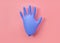 Surgical inflated blue glove on a pink background. Coronavirus, covid-19 concept