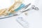 Surgical instruments forceps for closing a wound, curved tweezers, thread with needle, medical mask and rubber gloves on white bac