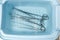Surgical instruments are rinsed in a tray with water.