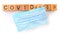 Surgical Mask With Wooden Cubes And Word Covid-19