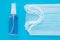 Surgical medical masks and hand sanitizer. Blue background. Coronavirus covid-19 prevention concept