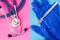 Surgical scalpel, medical protection gloves and medical stethoscope in two colors background: blue and pink. Concept of surgery, p