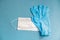 Surgical white mask and latex gloves for protection on a blue background