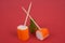 Surimi sticks with wooden picks next to a sprig of parsley close-up on a red background