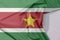 Suriname fabric flag crepe and crease with white space.