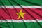 Suriname flag is depicted on a sports cloth fabric with many folds. Sport team banner