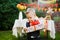 Surprise for the birthday. the boy is holding a box with a gift in the yard on the background of a festive table with a cake. dres