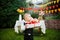 Surprise for the birthday. the boy is holding a box with a gift in the yard on the background of a festive table with a cake. dres