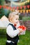 Surprise for the birthday. the boy is holding a box with a gift in the yard on the background of a festive table with a cake. dres