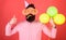 Surprise birthday party with balloons decoration. Bearded man in pink shirt showing thumb up. Hipster with huge glasses