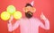 Surprise birthday party with balloons decoration. Bearded man in pink shirt showing thumb up. Hipster with huge glasses