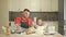 Surprise for mom. Dad and daughter, 5-6 years old, are kneading dough in the kitchen. It looks like a game.