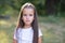 Surprise. Pretty funny little girl with long brown hair posing summer nature outdoor. Cute kid`s portrait. Beautiful child`s fac