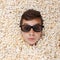 Surprise young boy in stereo glasses looking out of popcorn
