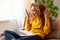 Surprised afro american woman having video call while working or studying online on sofa at home