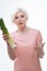 Surprised aged woman holding leek in right hand