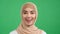 Surprised Arab woman exclaims wow on green background