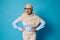 Surprised Arab woman in hijab with hands on waist expressing emotions on blue background