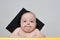 Surprised baby in an academic hat at the table. Educational concept