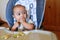 Surprised baby eating chicken with broccoli