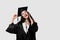 Surprised bachelor girl in graduation robe and cap on white background. Happy and funny young woman smile. Student