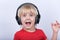 Surprised boy with headphones on white background. Portrait of boy listening music