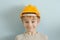 Surprised boy in the helmet of the builder. Blue background