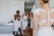 Surprised bridesmaids looking at bride in wedding gown