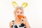 Surprised bunny woman eat carrot. Happy easter and funny easter day. Young woman wearing bunny ears on Easter day.