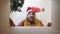 Surprised caucasian man in santa hat unpacking parcel box