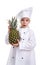 Surprised chef girl in a cap cook. Girl holding pineapple. Positive human emotion, facial expression feeling, attitude