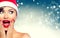 Surprised Christmas girl. Beauty woman in Santa`s hat