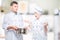 Surprised cook looks at soup in a pan of another chef