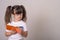 Surprised cute child in eyeglasses, writing in notebook using pencil, keeping mouth wide open. Four or five years, isolated