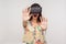 Surprised delighted woman in VR glasses standing with raised palms, playing video game saying wow