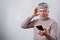 A surprised elderly man being shocked to watch news with his smartphone. Worried senior man reading text message on his smartphone