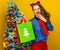 Surprised elegant woman looking at Christmas shopping bag