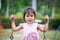 Surprised face of asian cute little girl while she playing swing