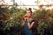 Surprised Farm Girl Holding a Tomato inside a Greenhouse