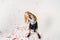 Surprised fashionably dressed curly hair tween girl in in denim jacket and black tutu skirt and rough boots on white background